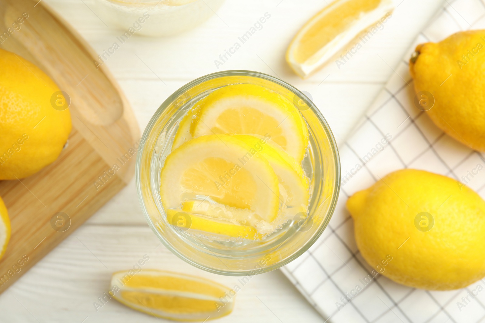 Photo of Soda water with lemon slices and fresh fruits on white wooden table, flat lay