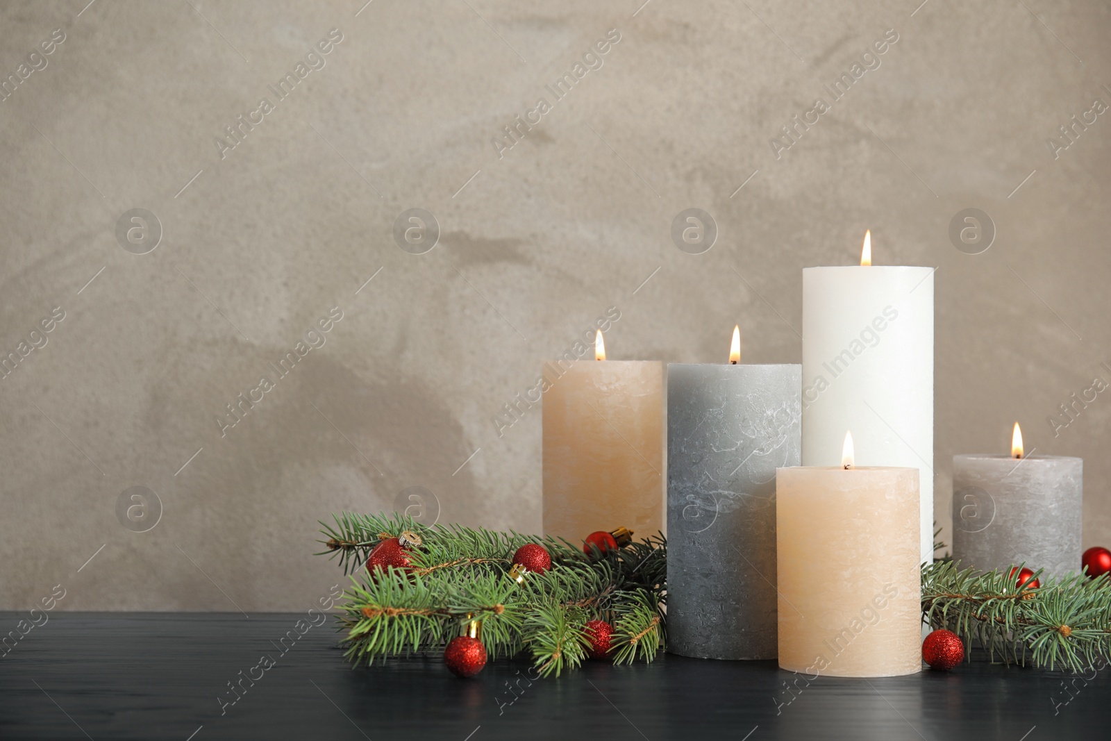 Photo of Burning candles with Christmas decoration on table. Space for text