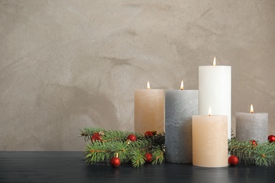 Photo of Burning candles with Christmas decoration on table. Space for text