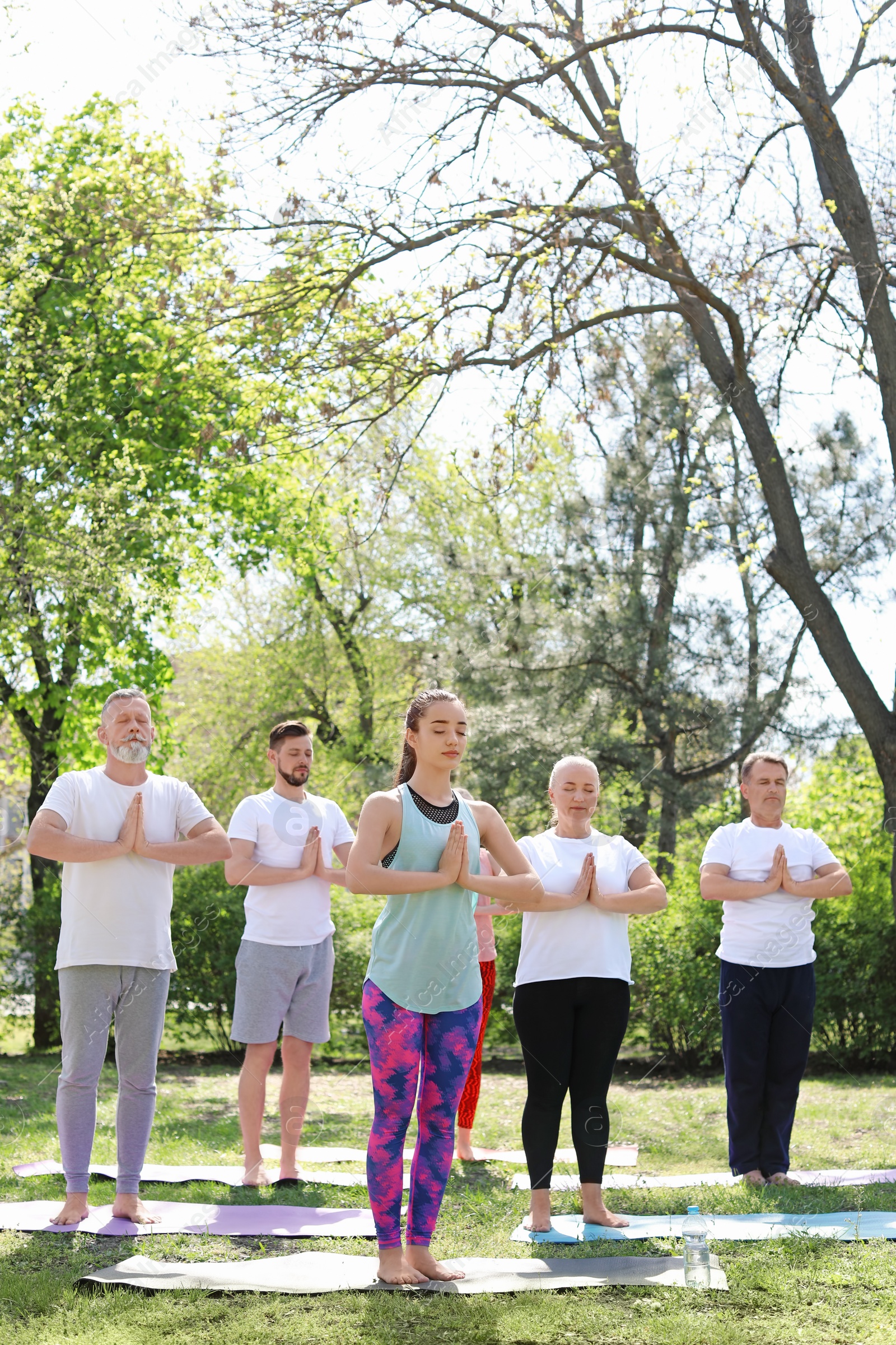 Photo of Group of people practicing yoga in park on sunny day