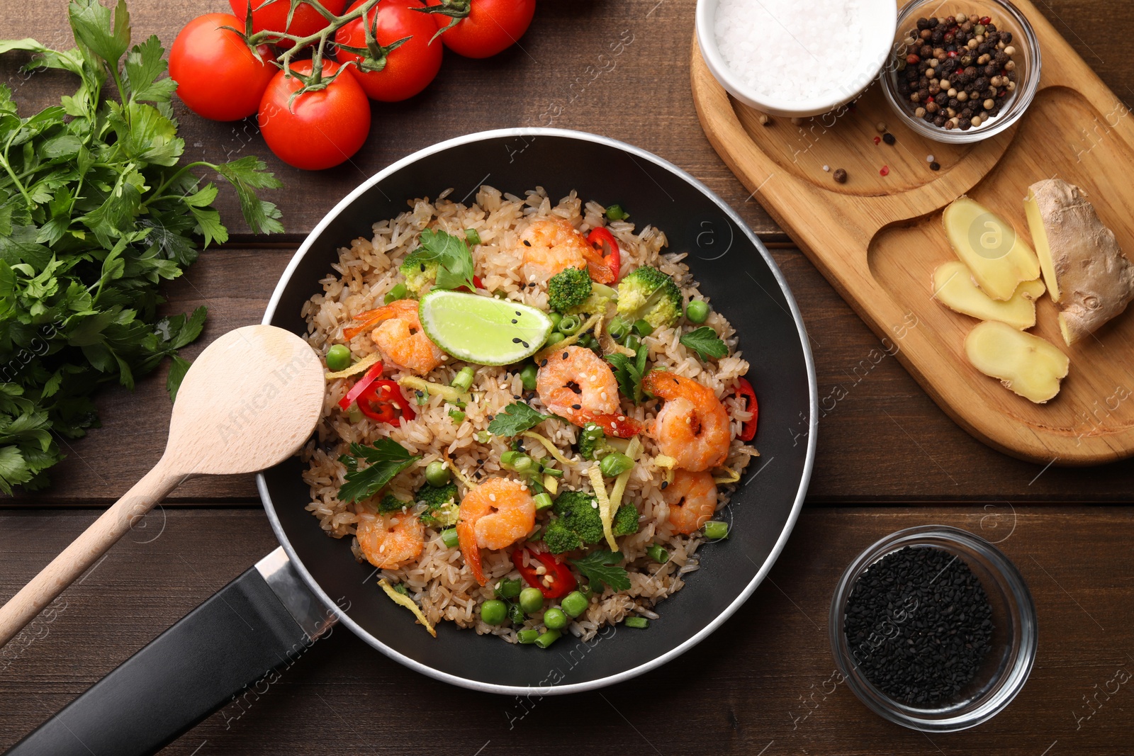 Photo of Tasty rice with shrimps and vegetables served on wooden table, flat lay