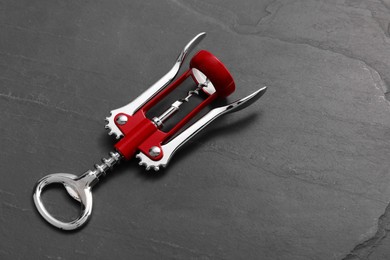 One wing corkscrew on grey textured table, above view. Space for text