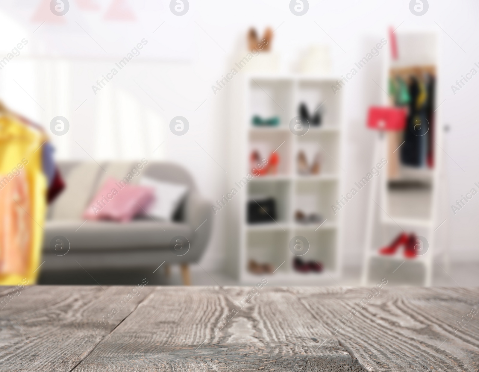 Image of Empty wooden surface and blurred view of shelving unit with shoes in store, space for text 