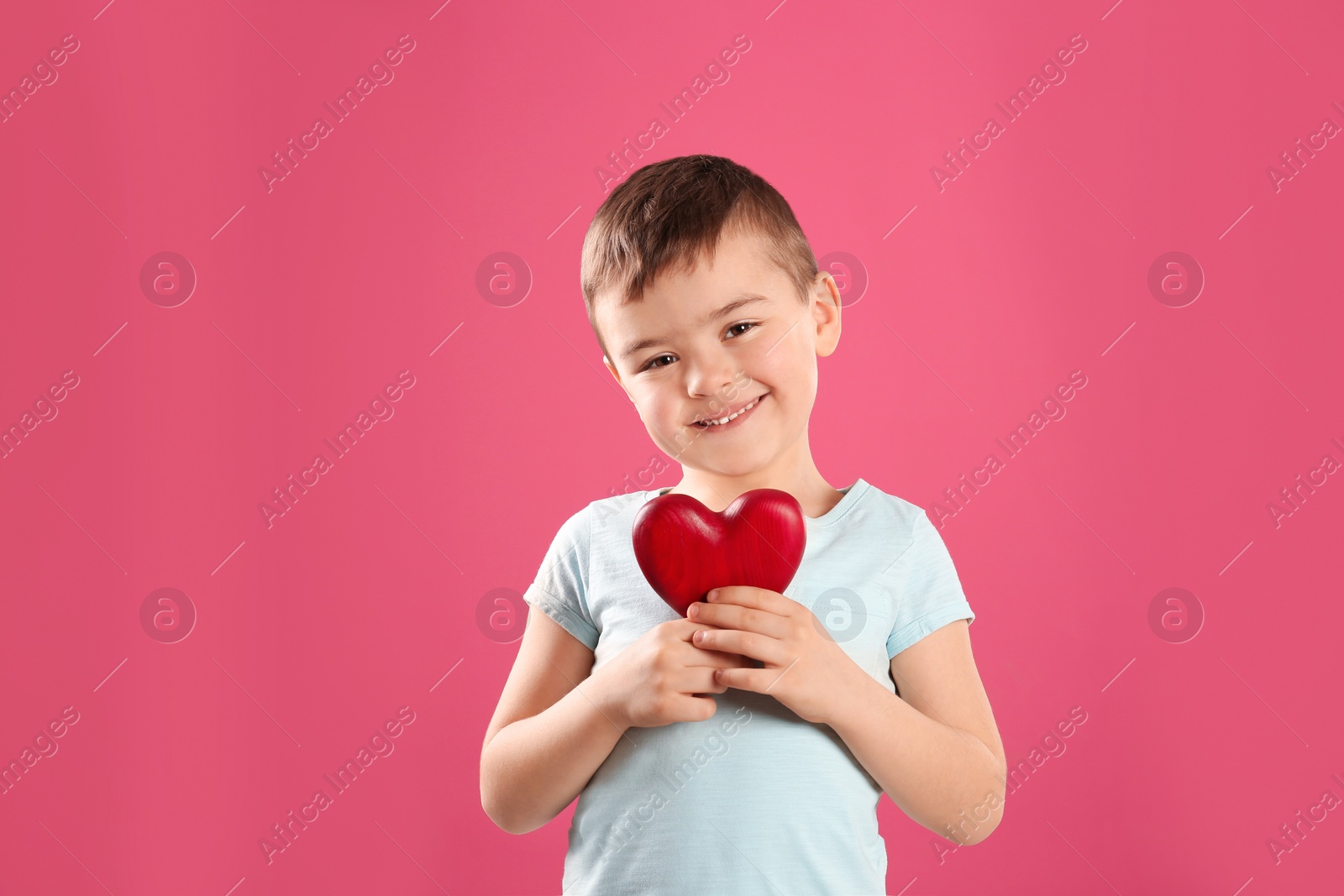 Photo of Portrait of boy with decorative heart on color background