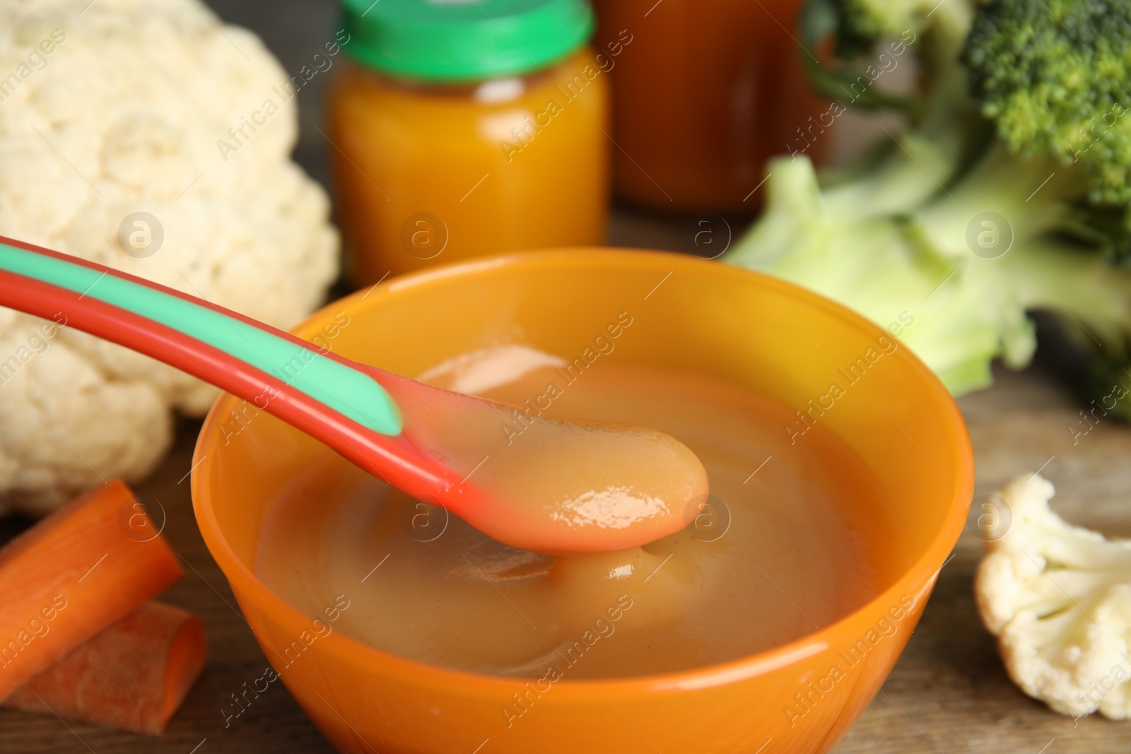 Photo of Healthy baby food and ingredients on wooden table, closeup