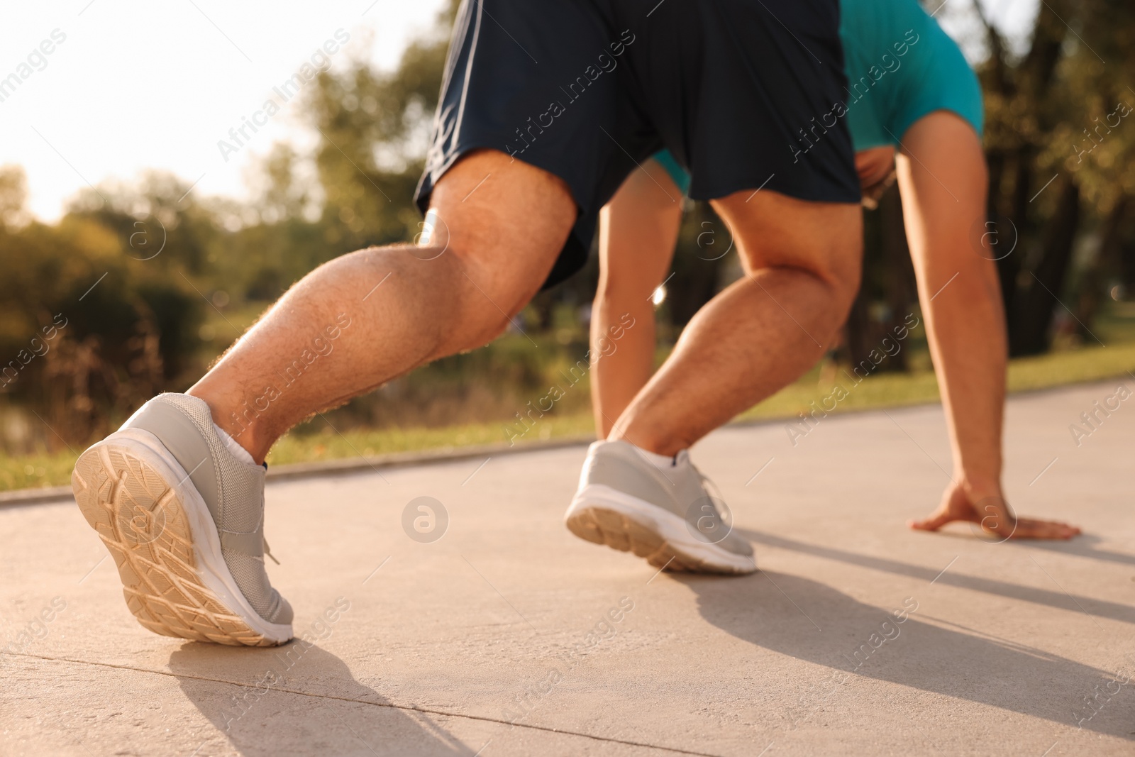 Photo of Runner on starting position in park on sunny day, closeup