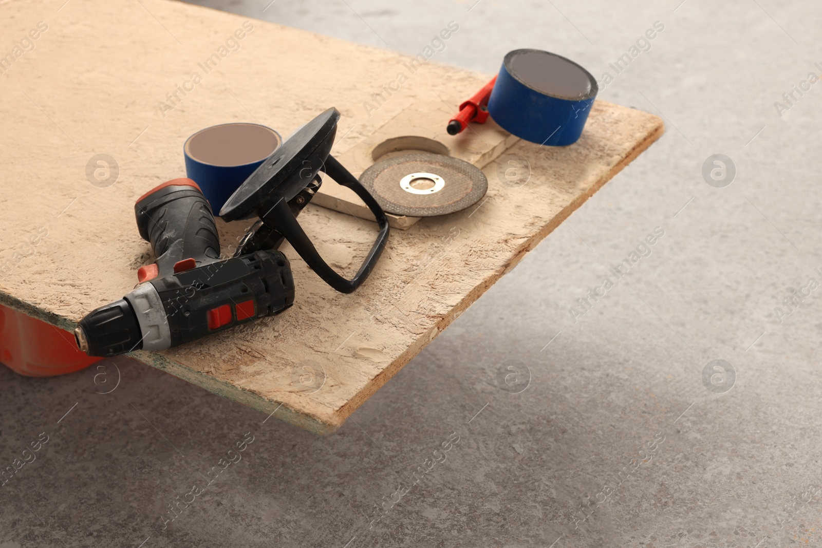 Photo of Different equipment on chipboard indoors. Tiles installation process