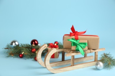 Photo of Beautiful Christmas composition with miniature sleigh on light blue background