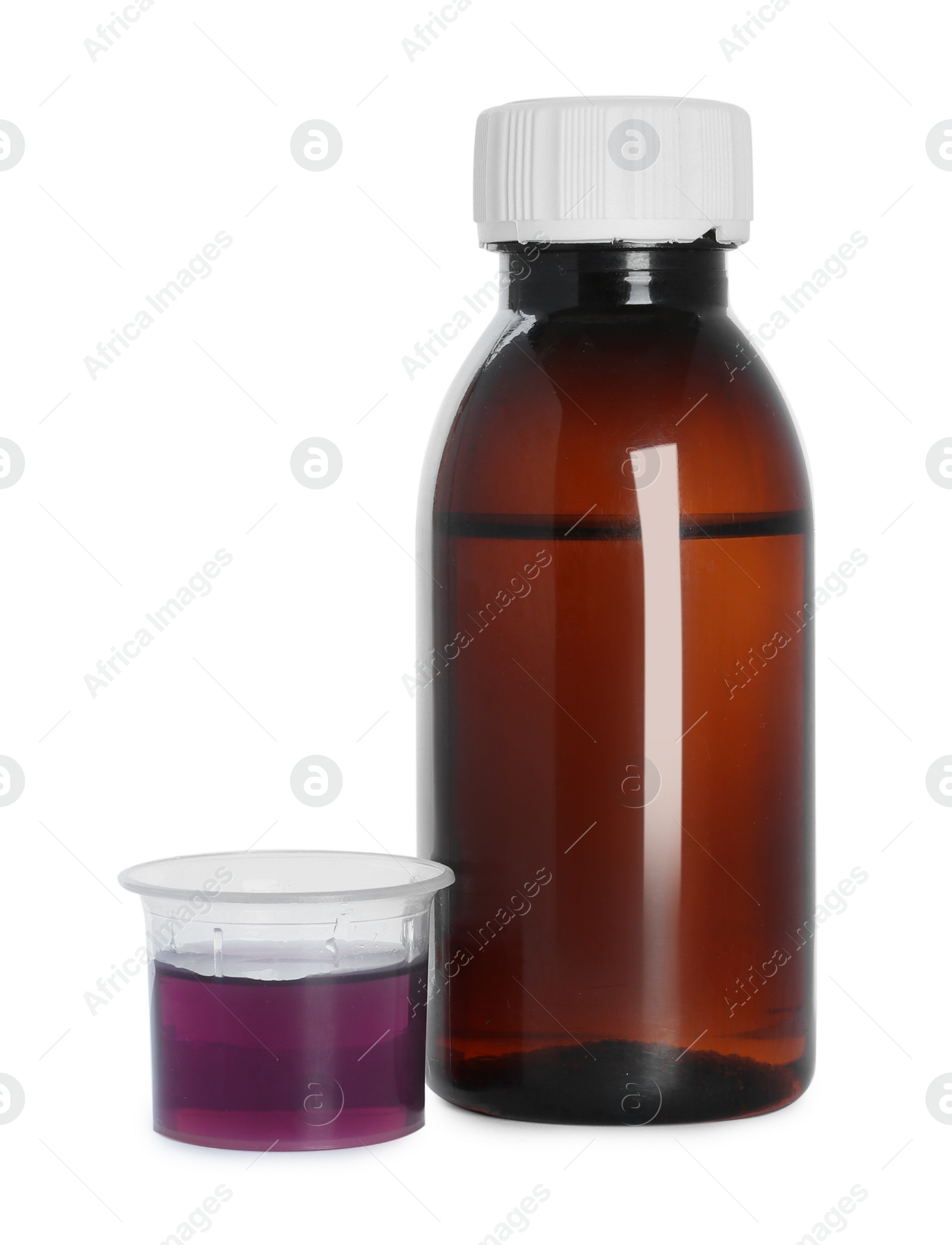 Photo of Bottle of cough syrup and measuring cup on white background