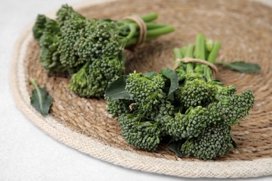 Photo of Fresh raw broccolini on white table, closeup. Healthy food
