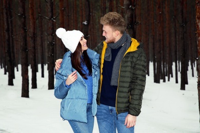 Beautiful young couple in snowy winter forest