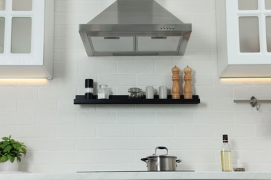 Photo of Modern range hood and furniture in kitchen