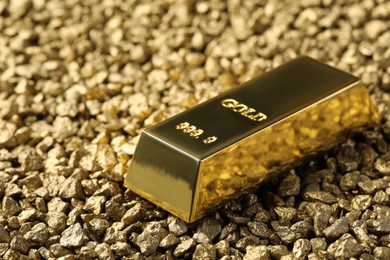 Photo of One gold ingot on nuggets, closeup view. Space for text