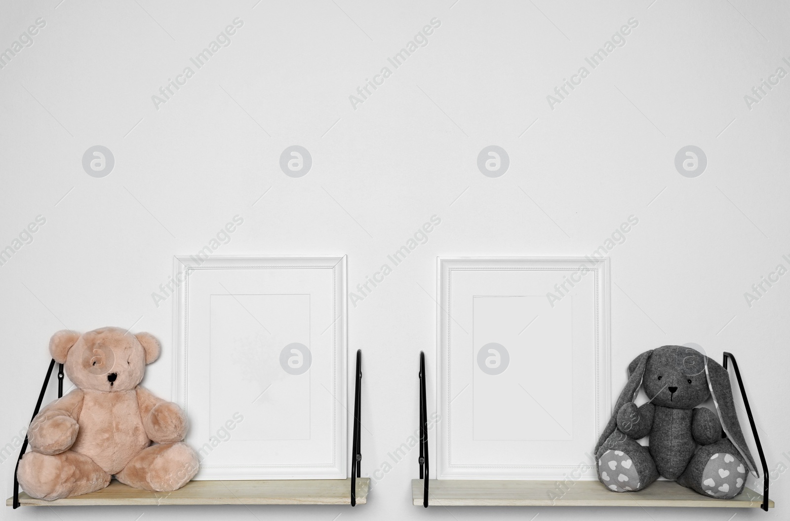 Photo of Soft toys and photo frames on shelf. Child room interior decor