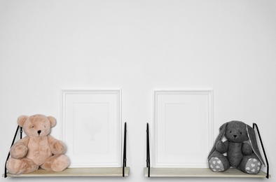 Photo of Soft toys and photo frames on shelf. Child room interior decor