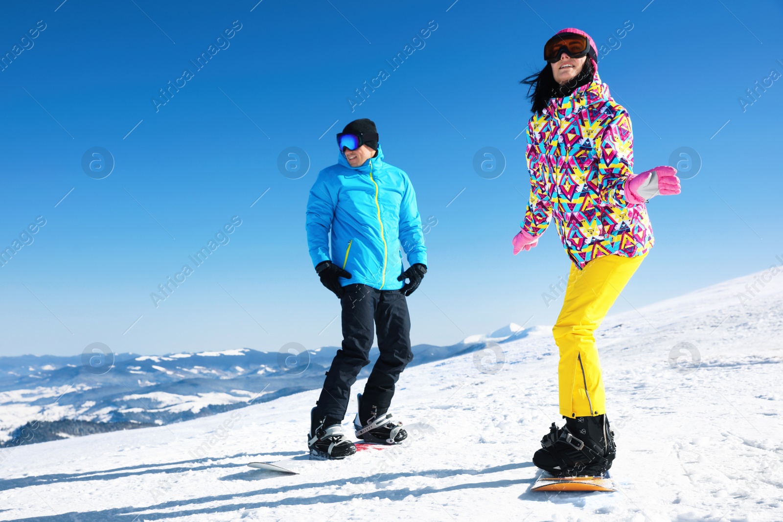 Photo of Couple snowboarding on snowy hill. Winter vacation