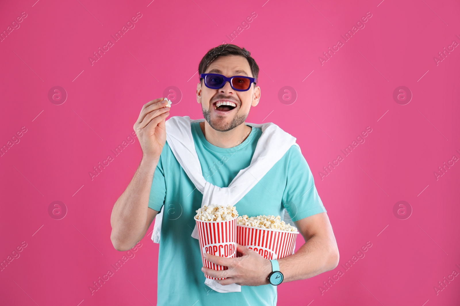 Photo of Man with 3D glasses and tasty popcorn on color background