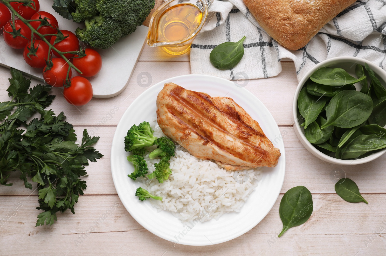 Photo of Grilled chicken breast and rice served with vegetables on wooden table, flat lay