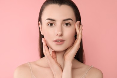 Portrait of beautiful young woman on pink background