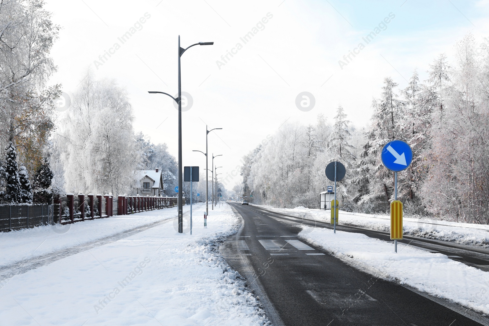 Photo of Beautiful view of city street with cottages and trees on winter day