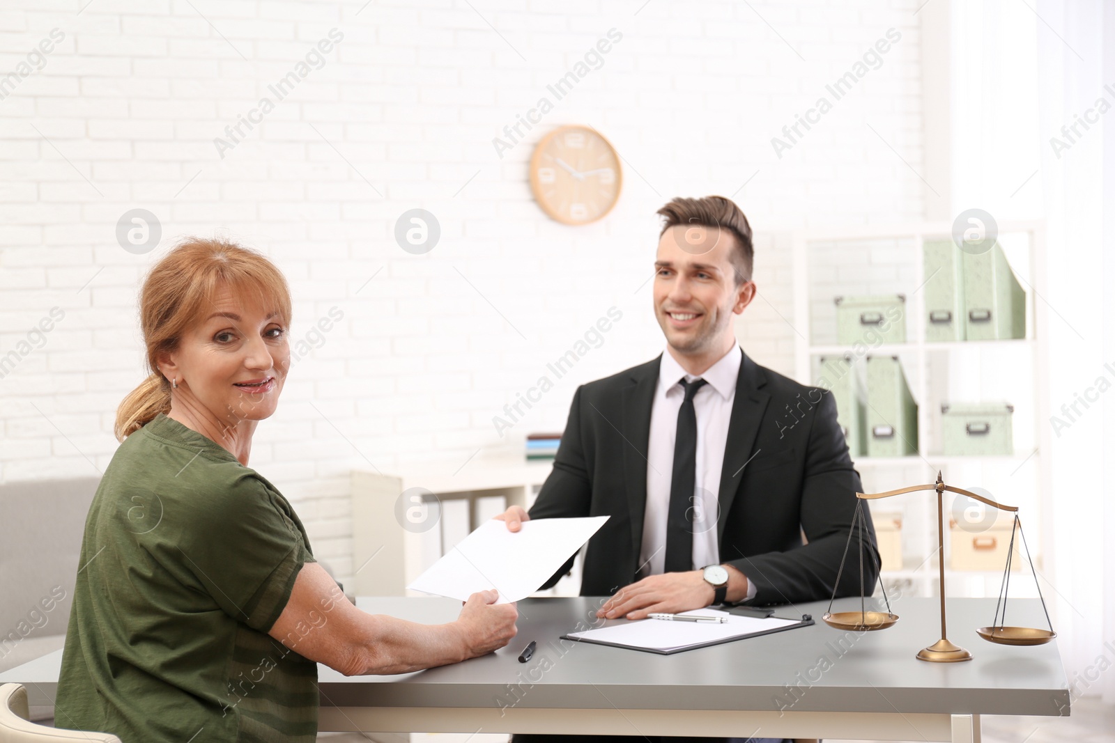 Photo of Young lawyer having meeting with senior client in office