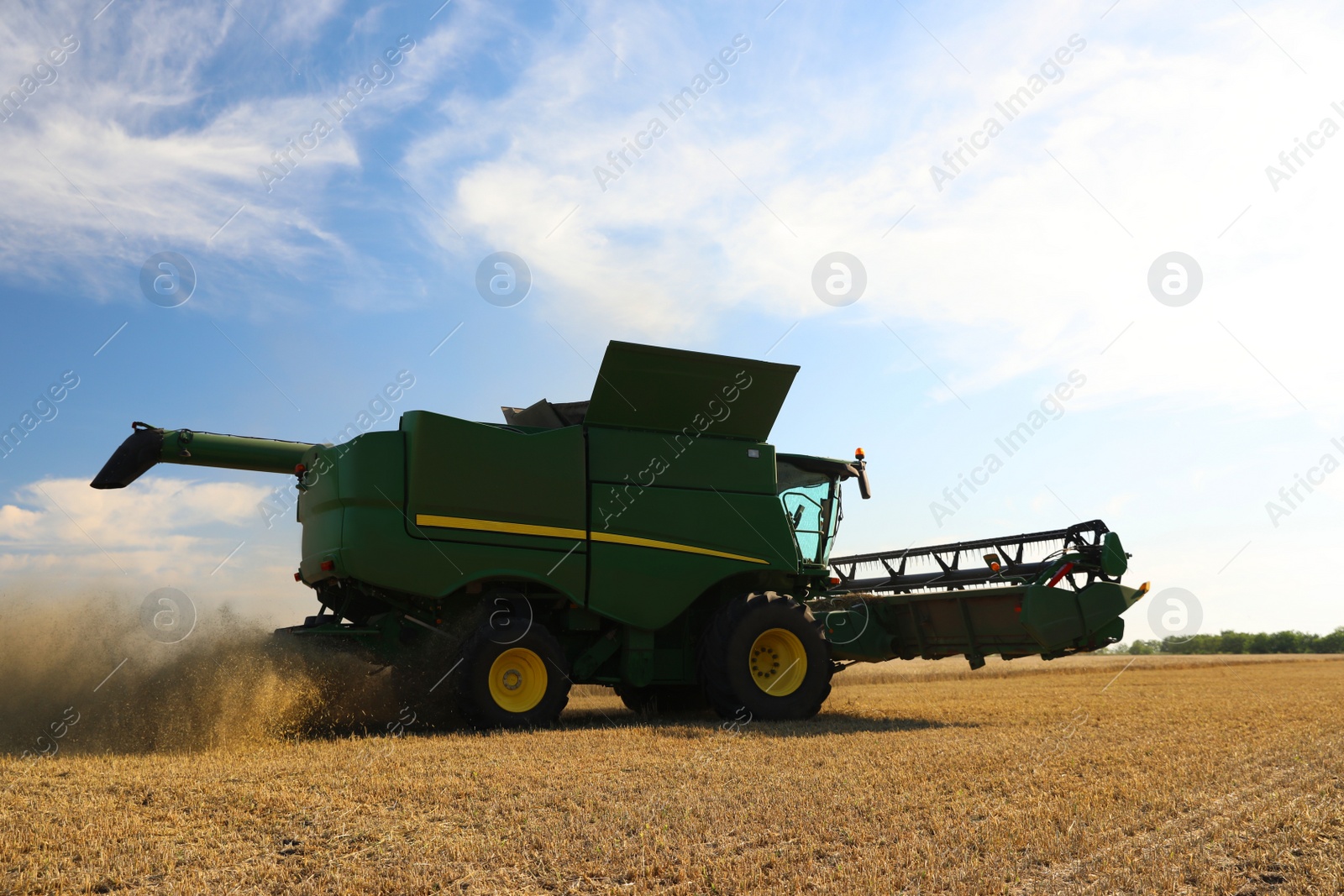 Photo of Modern combine harvester working in agricultural field