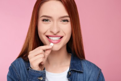 Beautiful woman with bubble gum on pink background