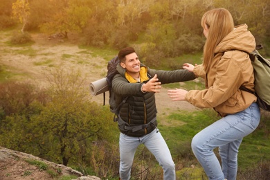 Couple of hikers with backpacks climbing down mountain