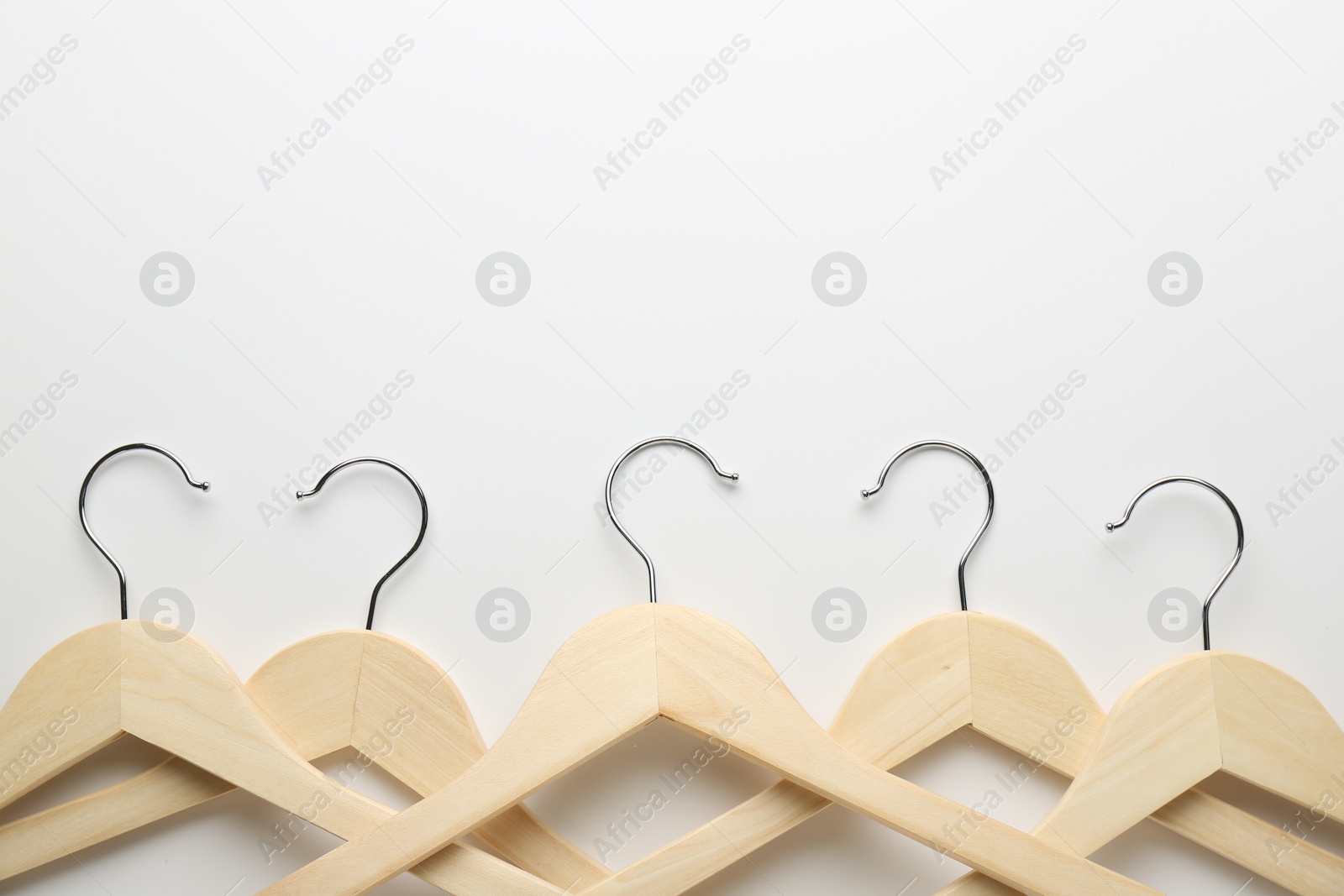 Photo of Wooden hangers on white background, flat lay. Space for text