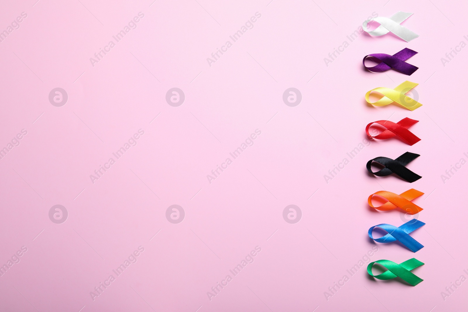 Photo of Colorful ribbons on pink background, flat lay with space for text. World Cancer Day