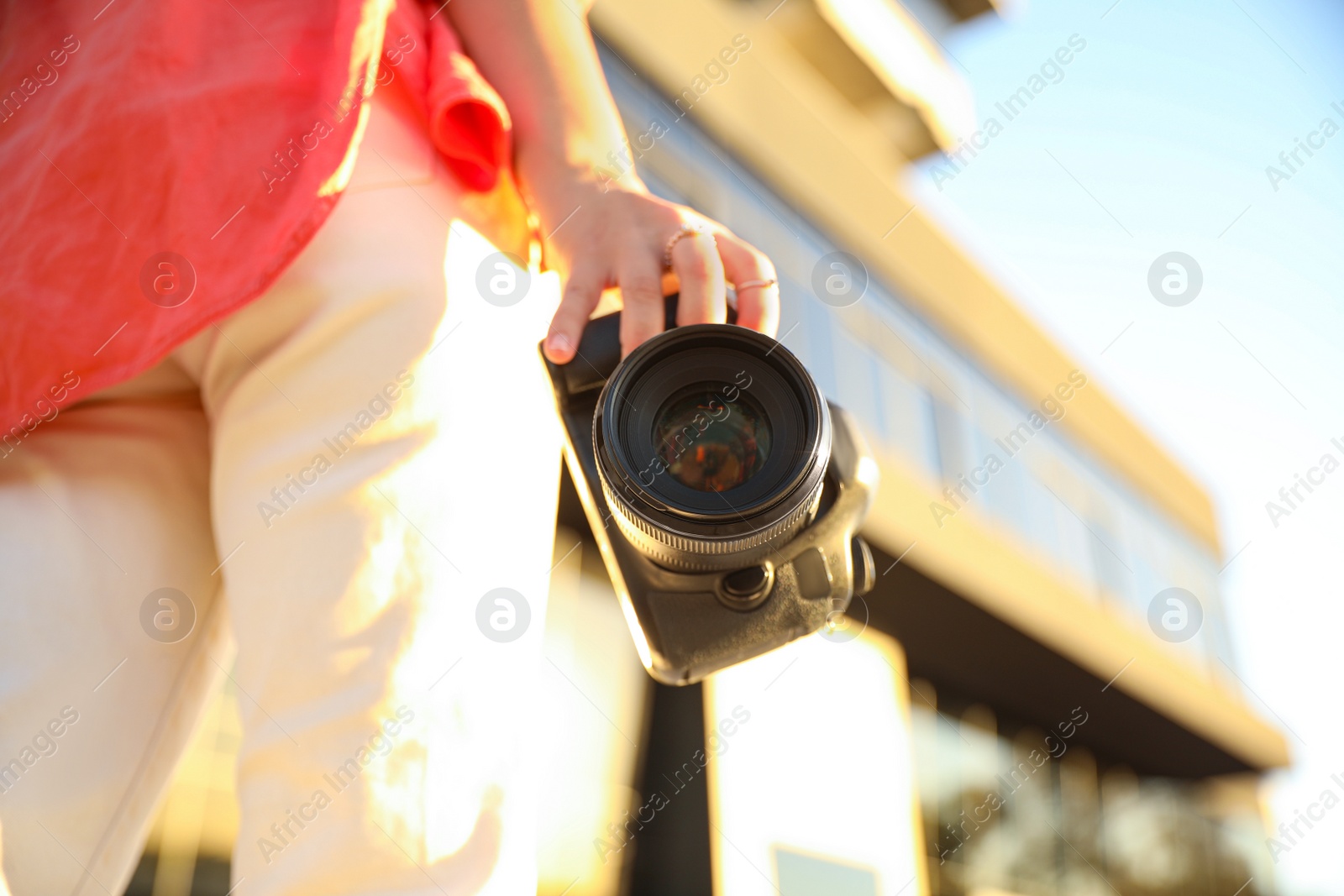 Photo of Young photographer with professional camera outdoors, closeup. Space for text