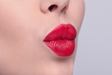 Woman with red lipstick on light background, closeup