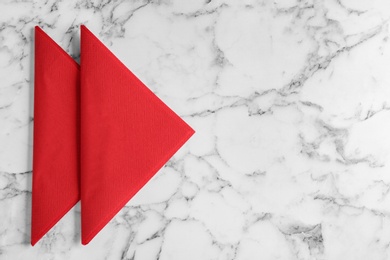 Photo of Red clean paper tissues on white marble table, flat lay. Space for text