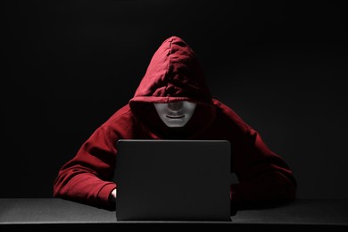 Hacker working with laptop in dark room. Cyber attack