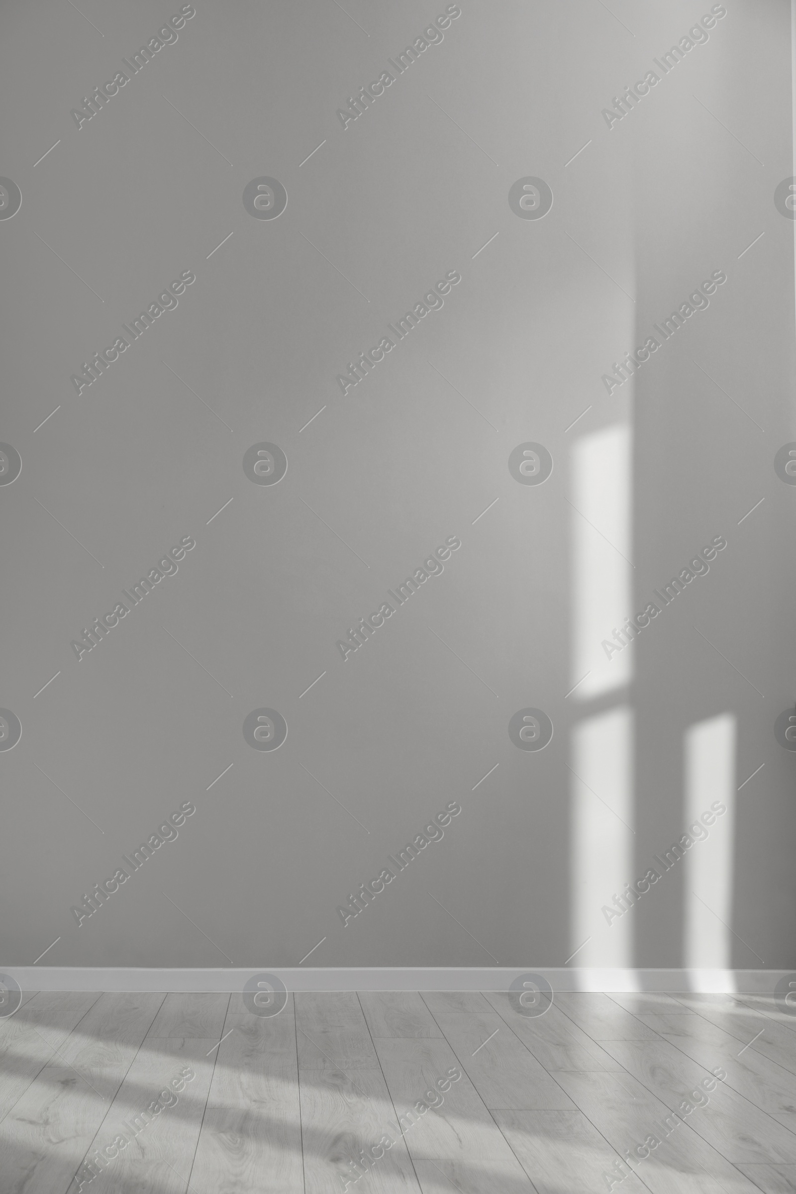 Photo of Light and shadows from window on floor and wall indoors