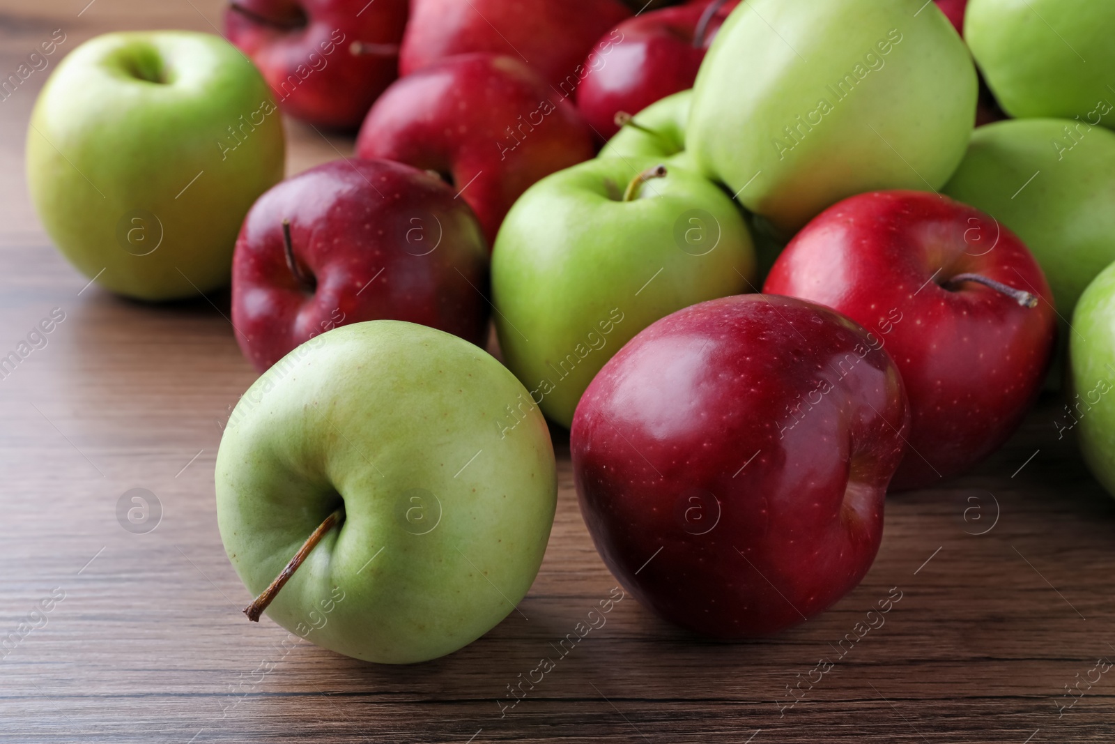 Photo of Fresh ripe red and green apples on wooden table, closeup