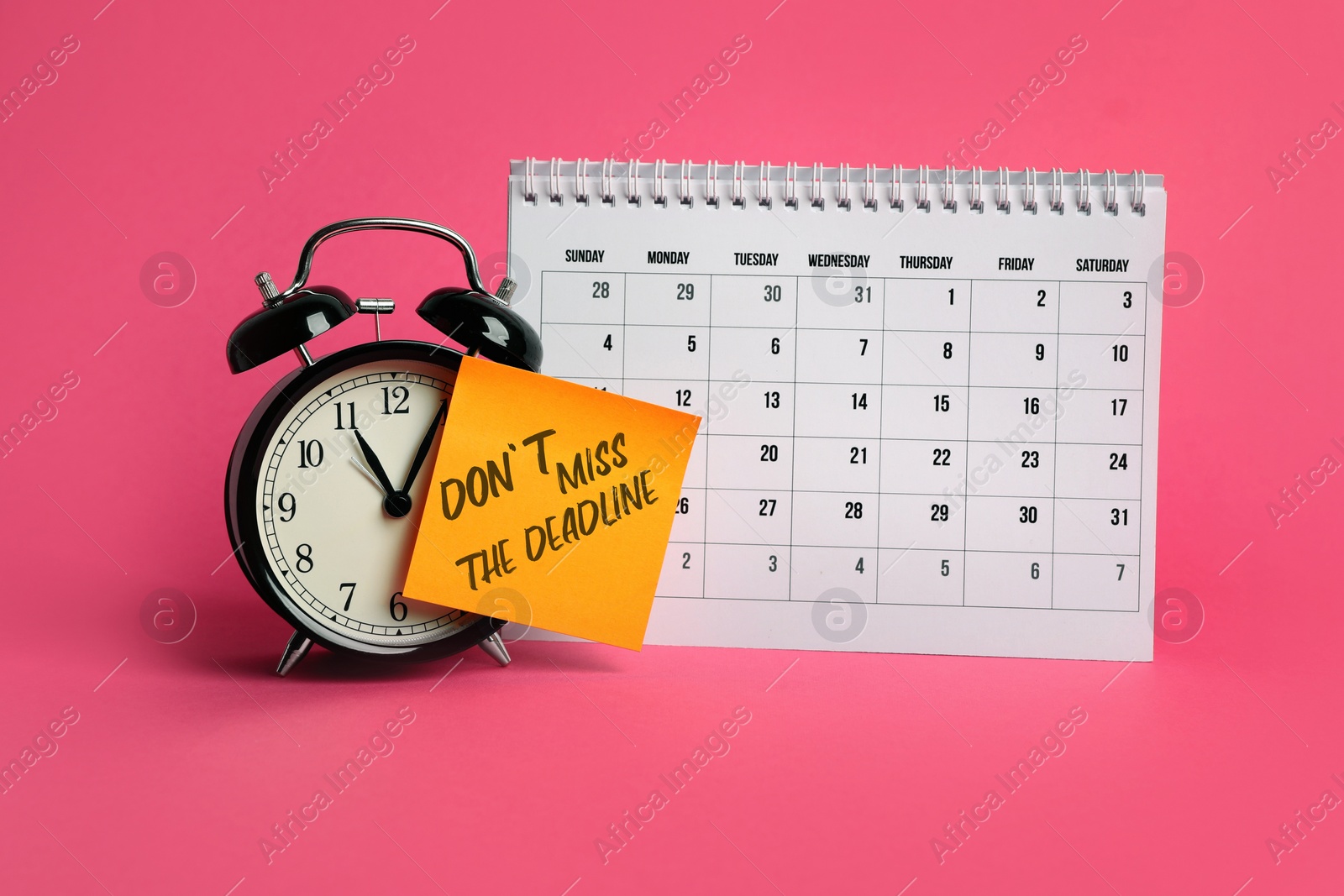 Image of Note with reminder Don't Miss The Deadline attached to alarm clock and calendar on pink background