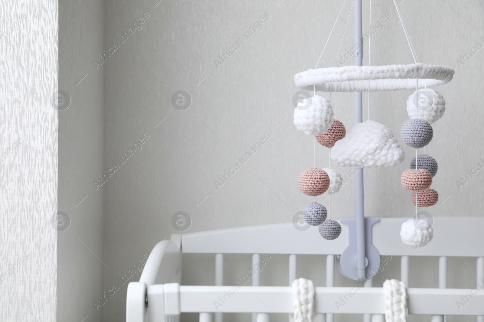 Photo of Modern baby mobile under crib in children's room