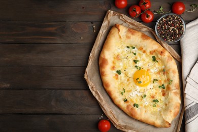 Fresh delicious Adjarian khachapuri served on wooden table, flat lay. Space for text