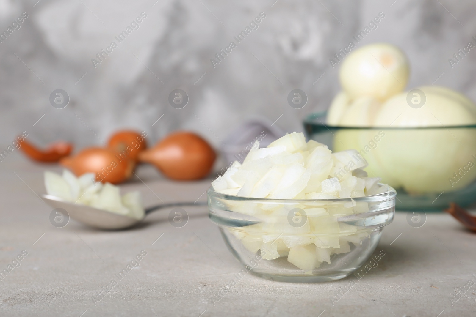 Photo of Glass bowl with cut onion on table