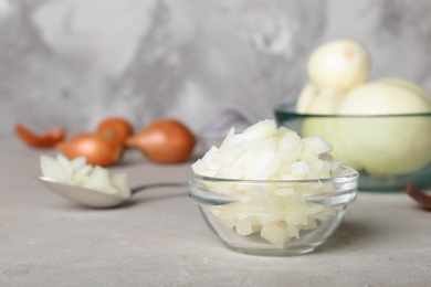 Glass bowl with cut onion on table