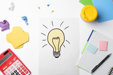 Photo of Workplace with drawing of light bulb and stationery on white background. Business trainer concept