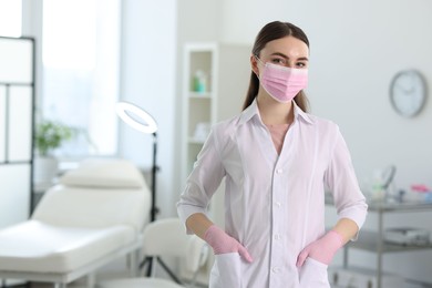 Photo of Cosmetologist in medical uniform in clinic, space for text