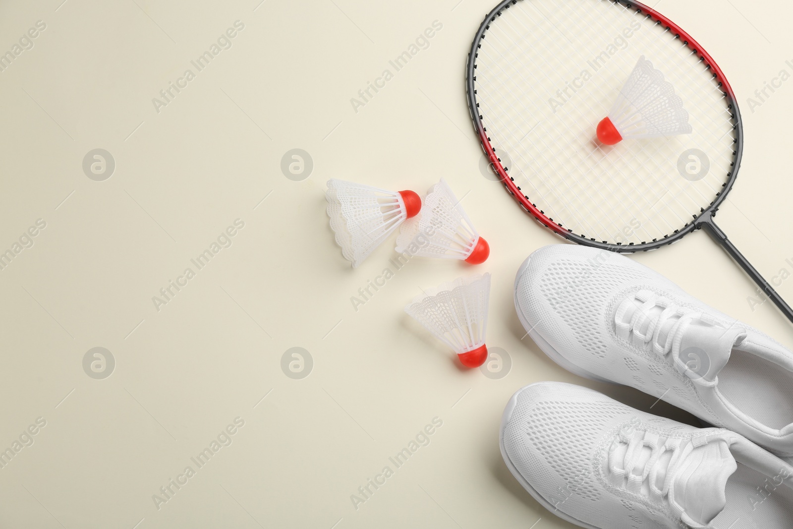 Photo of Badminton racket, shuttlecocks and shoes on light background, flat lay. Space for text