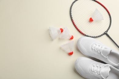 Badminton racket, shuttlecocks and shoes on light background, flat lay. Space for text