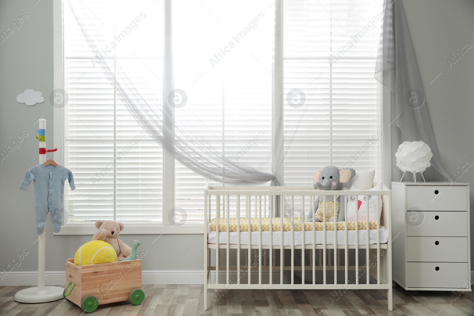 Photo of Stylish baby room interior with crib and toys