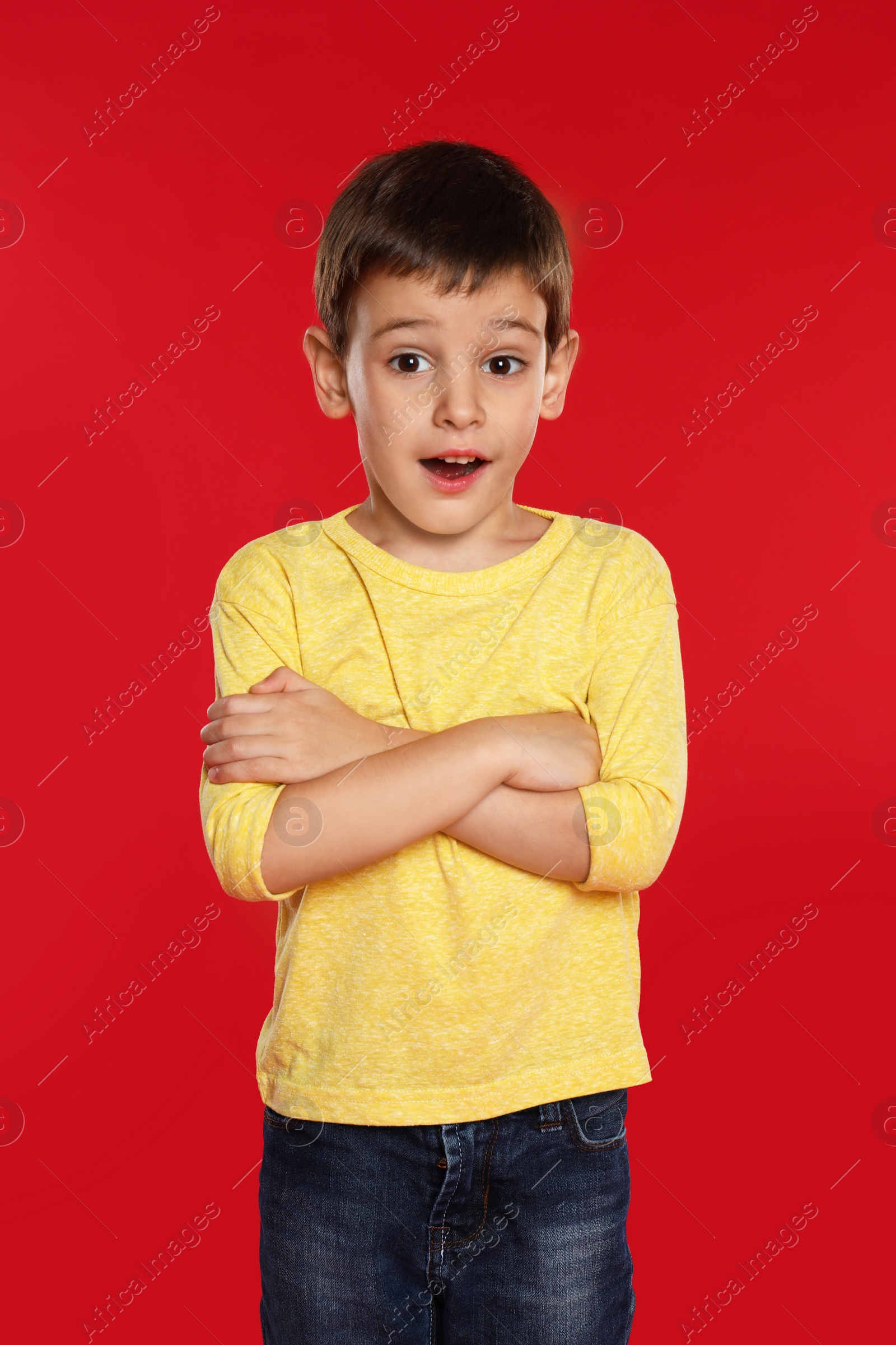 Photo of Portrait of emotional little boy on red background