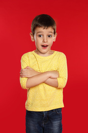 Portrait of emotional little boy on red background
