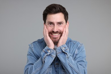 Photo of Portrait of happy surprised man on grey background