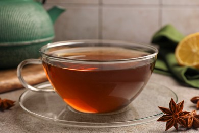 Aromatic tea with anise stars on light grey table, closeup